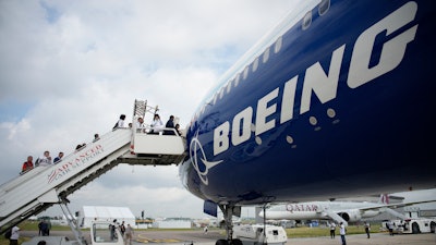 Visitors walk up the steps of the Boeing 777X airplane during the Paris Air Show in Le Bourget, north of Paris, France, Monday, June 19, 2023.