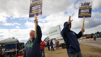 Striking United Auto Workers members Rob Marchese, left, and Neil Peters picket at the Stellantis Toledo Assembly Complex on Oct. 7, 2023, in Toledo, Ohio.