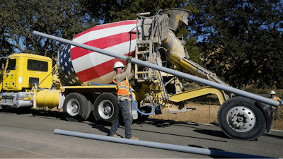 A truck drives past a Pacific Gas and Electric crew burying power lines in Vacaville, Calif., Wednesday, Oct. 11, 2023.
