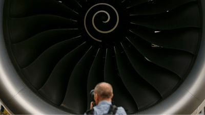 A visitor takes a photo of the Rolls-Royce jet engine of the Airbus A350-1000 parked at the static display area during the Singapore Airshow on Feb. 7, 2018, in Singapore.