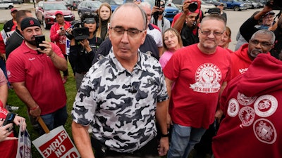 United Auto Workers President Shawn Fain talks with members picketing near a General Motors Assembly Plant in Delta Township, Mich., on Sept. 29, 2023.