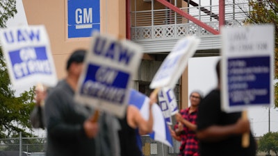 Ethan Pierce, left, a material handler of 23 years at General Motors, leads a line of picketers outside the company's assembly plant, Tuesday, Oct. 24, 2023, in Arlington, Texas.