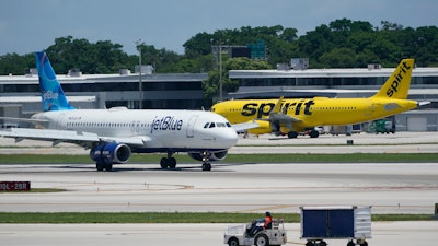 A JetBlue Airways Airbus A320, left, passes a Spirit Airlines Airbus A320 as it taxis on the runway, July 7, 2022, at the Fort Lauderdale-Hollywood International Airport in Fort Lauderdale, Fla.