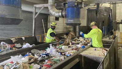 Recycling workers sort through materials.