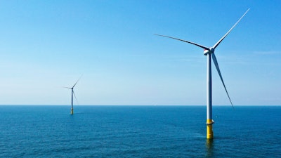 Two of the offshore wind turbines stand off the coast of Virginia Beach, Va., Monday, June 29, 2020.