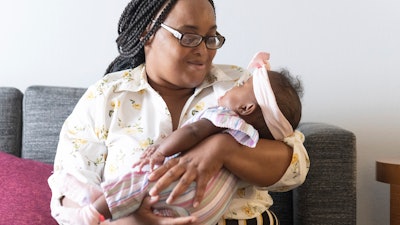Asian Davis, 33, of Sikeston, Mo., cradles her 8-month-old daughter, Mira White during an interview on Oct. 3, 2023, in St. Louis. Davis and her lawyers say Mira suffered brain damage in March after developing bacterial meningitis tied to powdered infant formula contaminated with Cronobacter sakazakii, a germ known to cause severe disease in young babies.