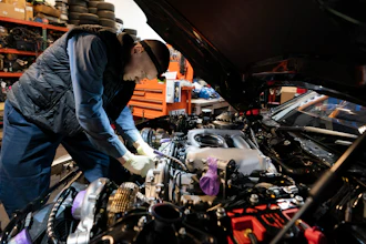 Mechanic David Stoliaruk works on the engine of a car at IC Auto in Philadelphia, May 2, 2023.