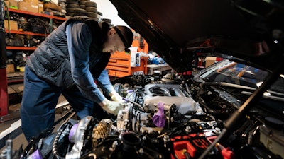 Mechanic David Stoliaruk works on the engine of a car at IC Auto in Philadelphia, May 2, 2023.
