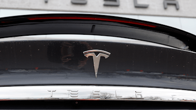 The Tesla company logo shines off the rear deck of an unsold 2020 Model X at a Tesla dealership, April 26, 2020, in Littleton, Colo.