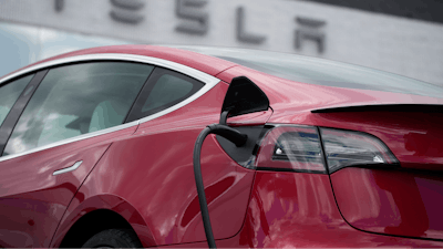 A 2021 Model 3 sedan charges at a Tesla dealership in Littleton, Colo., on June 27, 2021.