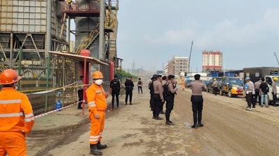 Police officers and workers stand near the site where a furnace explosion occurred at PT Indonesia Tsingshan Stainless Steel smelting plant in Morowali, Central Sulawesi, Indonesia, Sunday, Dec. 24, 2023.