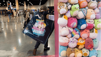 A shareholder leaves the Squishmallows booth with a large bag of purchases in the exhibition hall of the Berkshire Hathaway annual meeting on Saturday, May 6, 2023, in Omaha, Neb.