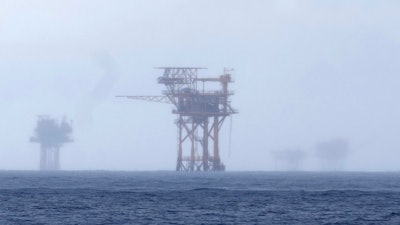 Oil platforms are visible through the haze near the Flower Garden Banks National Marine Sanctuary in the Gulf of Mexico, off the coast of Galveston, Texas, Sept. 16, 2023. Oil companies offered $382 million for drilling leases in the Gulf Wednesday after courts rejected the Biden administration's plans to scale back the sale to protect an endangered whale species.