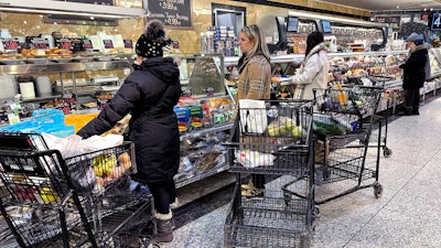 Customers wait for orders at a grocery store in Wheeling, Ill., Jan. 19, 2024.