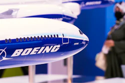 A woman walks by models of Boeing Co. aircraft, including the manufacturer's new Boeing 777X, at the Dubai Air Show in Dubai, United Arab Emirates, Wednesday, Nov. 17, 2021.