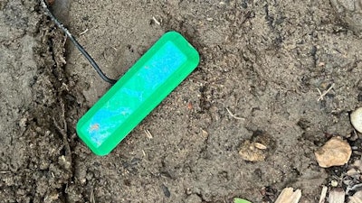 The fuel cell's 3D printed cap peeks above the ground. The cap keeps debris out of the device while enabling air flow.