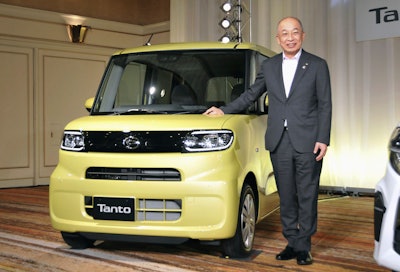 Japanese automaker Daihatsu President Soichiro Okudaira poses next to new type of 'Tanto' in Tokyo, on July 9, 2019.
