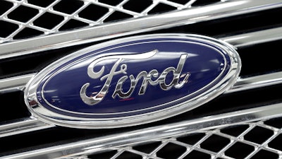 This Jan. 5, 2015, file photo shows a Ford logo shines on the front grille of a 2014 Ford F-150, on display at a local dealership in Hialeah, Fla.