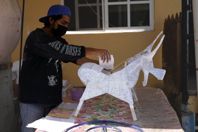 Edward Martinez makes a paper-mache bull to be stuffed with fireworks at his family's workshop in preparation for the annual festival in honor of Saint John of God, the patron saint of the poor and sick whom fireworks producers view as a protective figure, in Tultepec, Mexico, Tuesday, March 5, 2024.