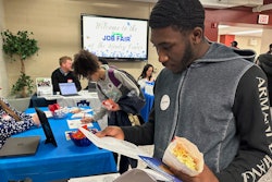 Job seeker Johannes Oveida looks over a brochure at a job fair at Lehigh Carbon Community College, Allentown, Pa., March 7, 2024.
