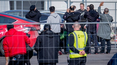 Tesla CEO Elon Musk, 4th from right, arrives at the Tesla Gigafactory for electric cars in Gruenheide near Berlin, Germany, Wednesday, March 13, 2024.