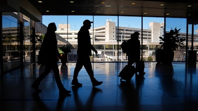 Travelers walk through Philadelphia International Airport, Feb. 16, 2024.
