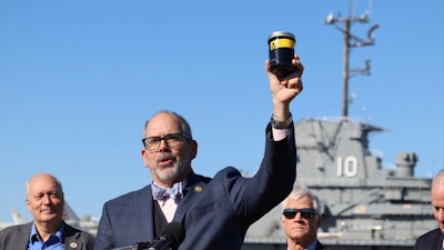 South Carolina Department of Natural Resources Director Robert Boyles holds a jar of toxic waste outside the USS Yorktown at a press conference in Mount Pleasant, S.C., on Tuesday, March 19, 2024. Officials are preparing to remove over 1.2 million gallons of hazardous liquids from the World War II-era aircraft carrier.