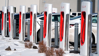 Motorists recharge their Tesla vehicles at a Tesla supercharging location, Jan. 16, 2024, in northeast Denver.