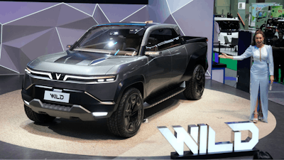 A Thai model poses next to Vinfast's electric concept pickup trucks called 'Wild' during the 45th Bangkok Motor Show in Nonthaburi, Thailand, Tuesday, March 26, 2024.