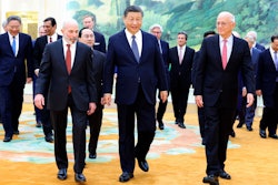 In this photo released by Xinhua News Agency, Chinese President Xi Jinping, center, walks with representatives from American business, strategic and academic communities at the Great Hall of the People in Beijing, March 27, 2024.