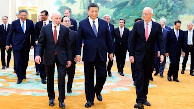 In this photo released by Xinhua News Agency, Chinese President Xi Jinping, center, walks with representatives from American business, strategic and academic communities at the Great Hall of the People in Beijing, March 27, 2024.
