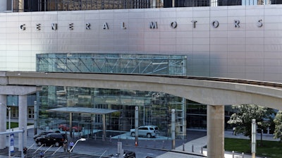 People exit the General Motors World Headquarters building in Detroit, Michigan, in 2014.
