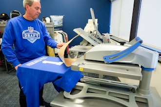 Brent Kisha, STAHLS' vice president of strategic sales, demonstrates using a Hotronix Fusion IQ heat press to put a name on shirt in St. Clair Shores, Mich., Monday, April 22, 2024.