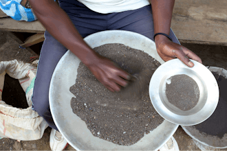 A Congolese miner sifts through ground rocks to separate out the cassiterite, the main ore that's processed into tin, in the town of Nyabibwe, eastern Congo, Aug. 16, 2012.