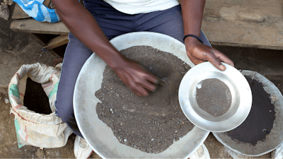 A Congolese miner sifts through ground rocks to separate out the cassiterite, the main ore that's processed into tin, in the town of Nyabibwe, eastern Congo, Aug. 16, 2012.