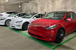 This photo provided by Edmunds shows a line of parked Tesla Model 3 and Model Y vehicles.