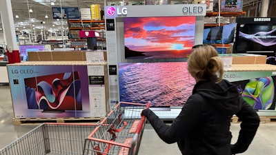 A shopper passes a display of televisions at a Costco warehouse, Lone Tree, Colo., April 29, 2024.