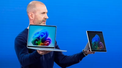 Brett Ostrum, Microsoft corporate vice president of Surface, holds up the new Surface Laptop and Surface Pro with built-in AI hardware during a showcase event of the company's AI assistant, Copilot, at Microsoft headquarters, Monday, May 20, 2024, in Redmond, Wash.