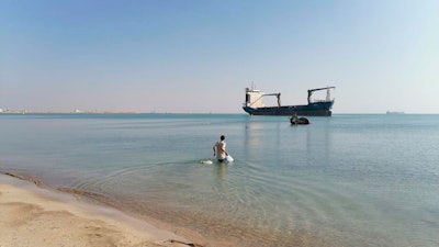 Mohammad Aisha carries bags to the abandoned cargo ship MV Aman in Egyptian waters, March 2021.