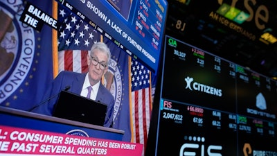 A screen displays a news conference with Federal Reserve Chairman Jerome Powell on the floor of the New York Stock Exchange, May 1, 2024.