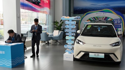 Sales staff stand near the Seagull electric vehicle from Chinese automaker BYD at a showroom in Beijing.