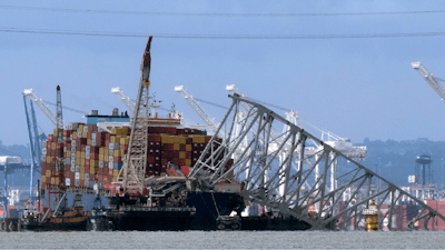 The collapsed Francis Scott Key Bridge rests on the container ship Dali, May 12, 2024, in Baltimore, as seen from Riviera Beach, Md.