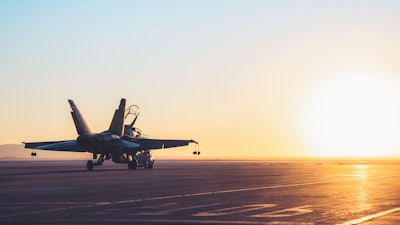 Jet fighter on an aircraft carrier deck.