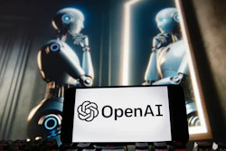 The OpenAI logo is displayed on a cellphone with an image on a computer monitor generated by ChatGPT's Dall-E text-to-image model.