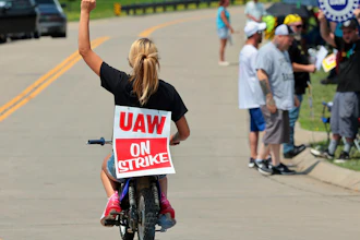 Lear production worker Abigail Fletcher rides her mini bike in support of the picket line as members of United Auto Workers Local 282 continue their strike against the car and truck seat manufacturer in Wentzville, Mo. on Tuesday, July 23, 2024.