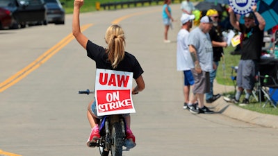 Lear production worker Abigail Fletcher rides her mini bike in support of the picket line as members of United Auto Workers Local 282 continue their strike against the car and truck seat manufacturer in Wentzville, Mo. on Tuesday, July 23, 2024.