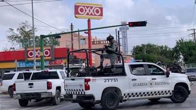 Mexican soldiers stand guard outside an Oxxo grocery shop near the Tamaulipas Chamber of Commerce, Matamoros, Mexico.