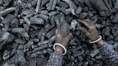 A woman works at a coal depot in Ahmedabad, India.