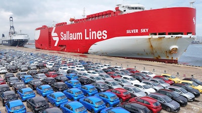 New cars wait for transportation near a Sallaum Lines ro-ro ship seen by the dock in Yantai in east China's Shandong province.
