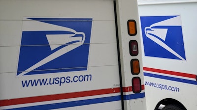 U.S. Postal Service delivery vehicles are parked outside a post office in Boys Town, Neb., Aug. 18, 2020.